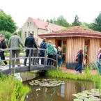 Domek ekologiczny - zbudowany z drewna, ściany wypełnione wewnątrz glinobitką i bielone wapnem, na dachu naturalna izolacja i jednocześnie ogródek - służy za sklepik z pamiątkami